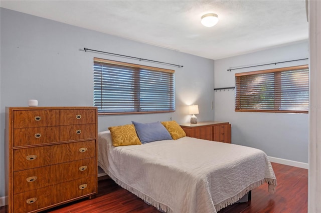 bedroom featuring baseboards and dark wood-type flooring