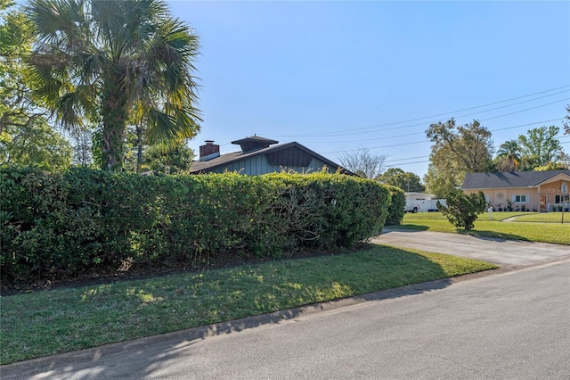 view of side of home with a yard and a chimney