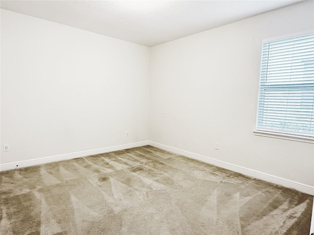 carpeted empty room with baseboards