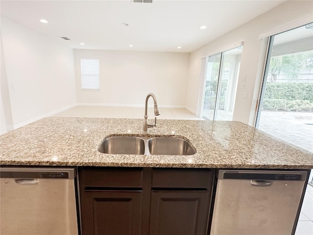 kitchen featuring a sink, open floor plan, stainless steel dishwasher, and a center island with sink