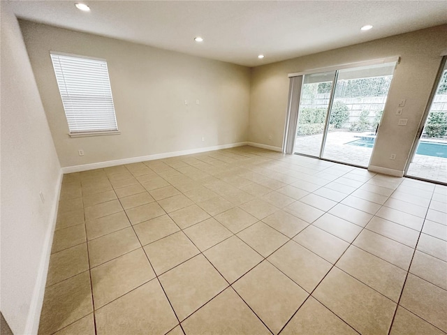 empty room with light tile patterned flooring, recessed lighting, and baseboards