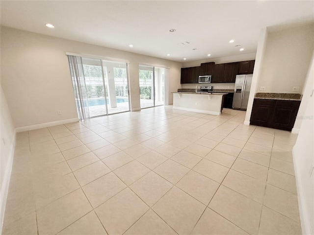 unfurnished living room with light tile patterned flooring, recessed lighting, and baseboards