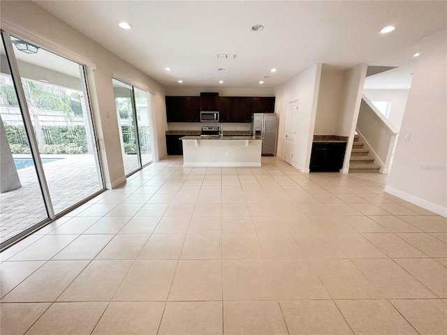 kitchen featuring light tile patterned flooring, recessed lighting, stainless steel appliances, and baseboards