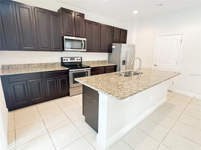 kitchen featuring light tile patterned floors, recessed lighting, a kitchen island with sink, a sink, and appliances with stainless steel finishes