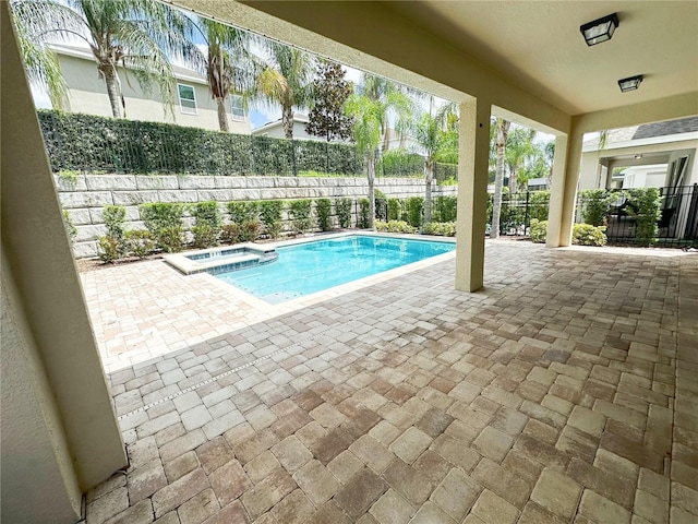 view of swimming pool featuring a patio area, a pool with connected hot tub, and fence private yard