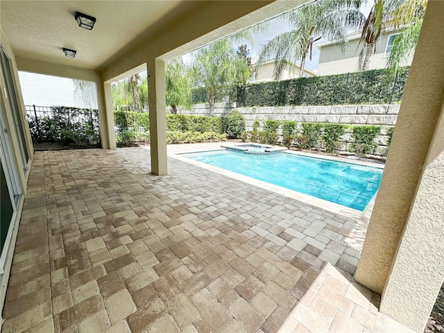 view of swimming pool with a patio area, a pool with connected hot tub, and a fenced backyard