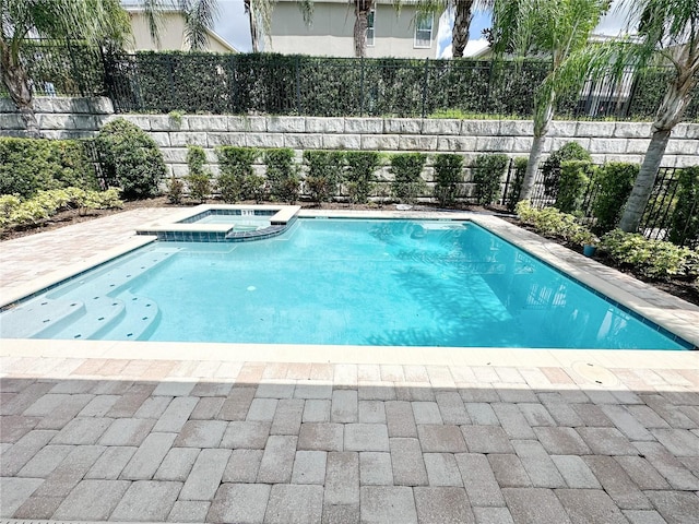 view of swimming pool with a patio area, fence, and a pool with connected hot tub