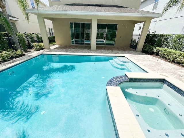 view of pool with fence, a pool with connected hot tub, and a patio area