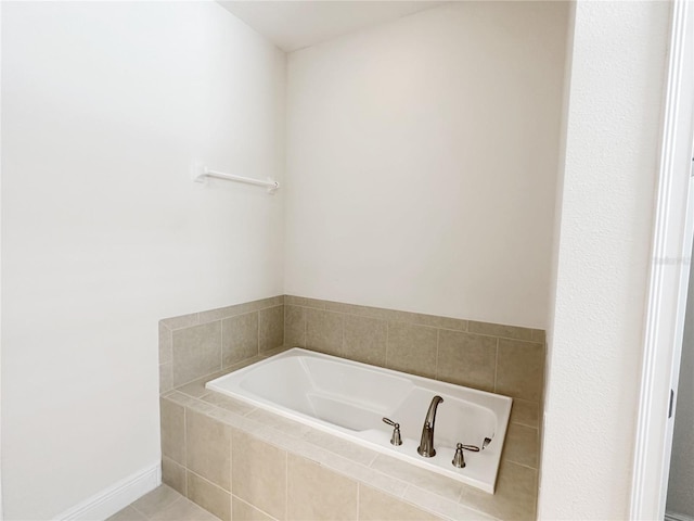 bathroom with a bath and baseboards