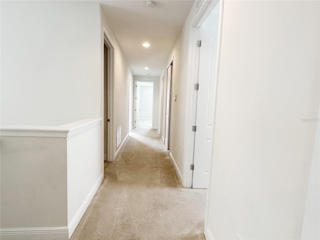 corridor featuring light carpet, visible vents, recessed lighting, and baseboards