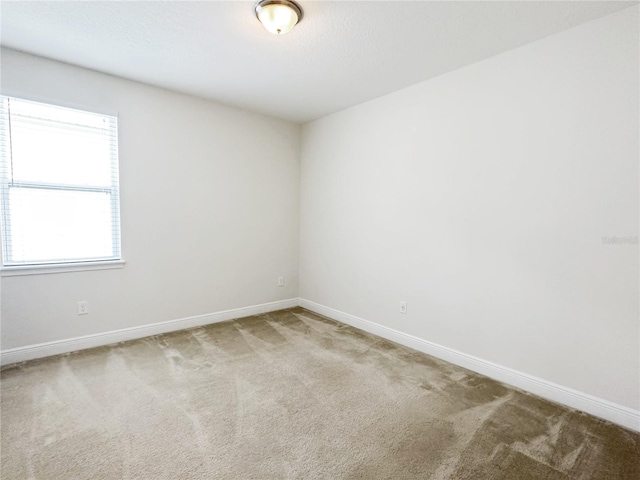 empty room with baseboards and carpet