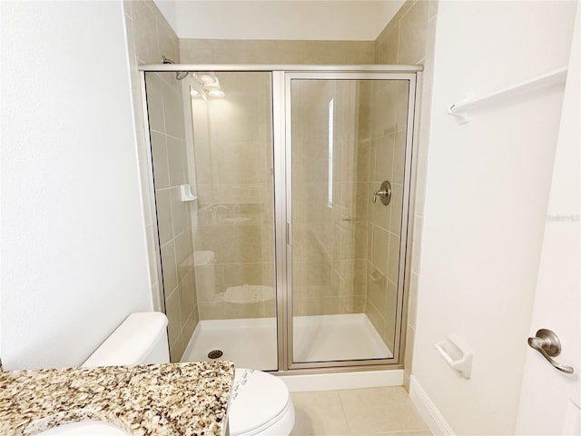 bathroom with tile patterned flooring, a stall shower, toilet, and vanity