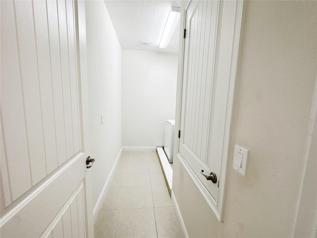 interior space with tile patterned flooring, visible vents, a textured ceiling, and baseboards