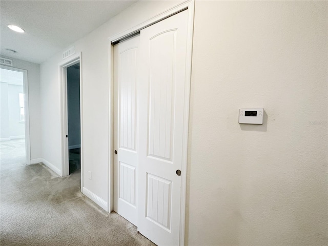 hallway with recessed lighting, visible vents, baseboards, and carpet flooring