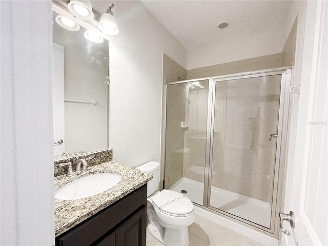 bathroom with vanity, a shower stall, toilet, and tile patterned floors