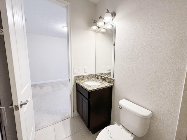 bathroom with vanity, tile patterned floors, toilet, and baseboards