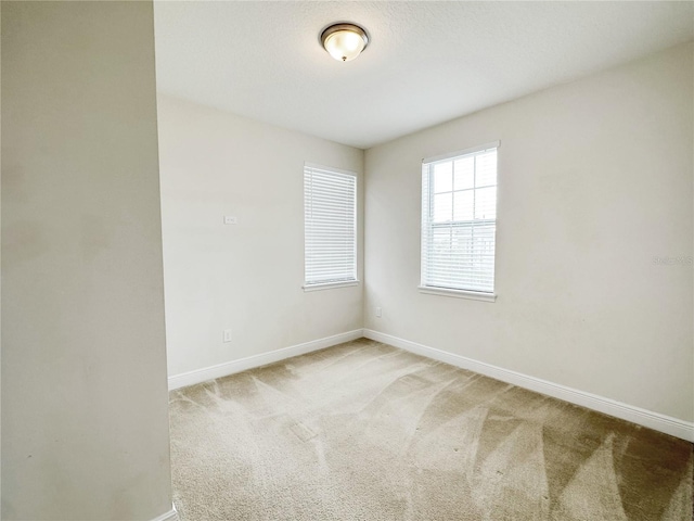 unfurnished room with baseboards and carpet floors