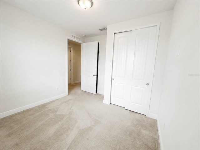 unfurnished bedroom featuring visible vents, carpet, and a closet