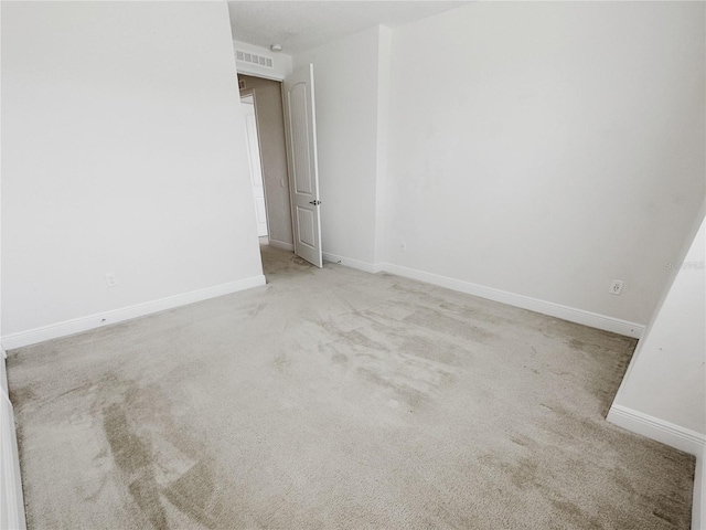 carpeted spare room with baseboards and visible vents