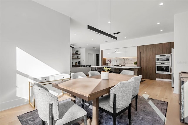 dining area with recessed lighting and light wood-style floors