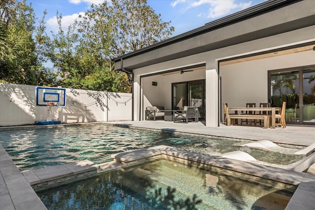 view of pool with a patio area, a pool with connected hot tub, outdoor lounge area, and fence