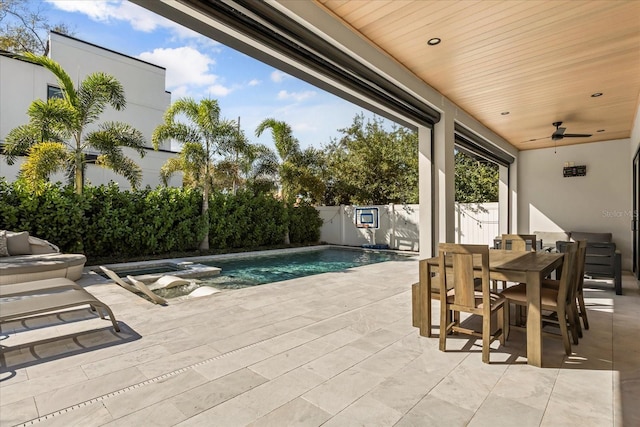 view of pool with a pool with connected hot tub, a fenced backyard, a patio area, outdoor dining space, and a ceiling fan