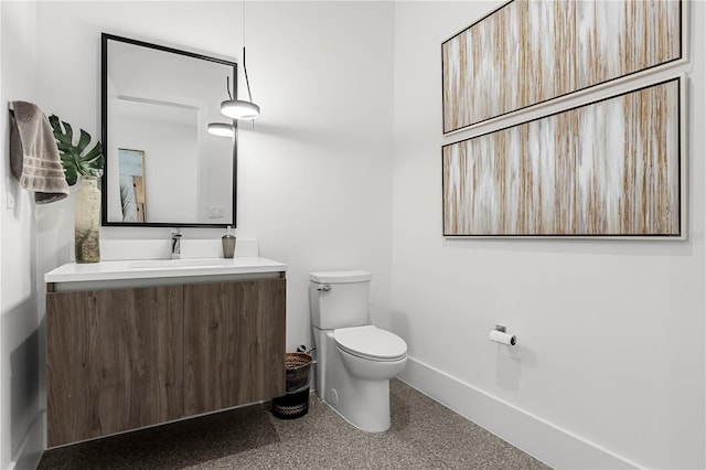 bathroom featuring vanity, toilet, and baseboards