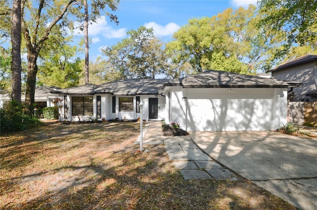 view of front facade with concrete driveway, a garage, and stucco siding