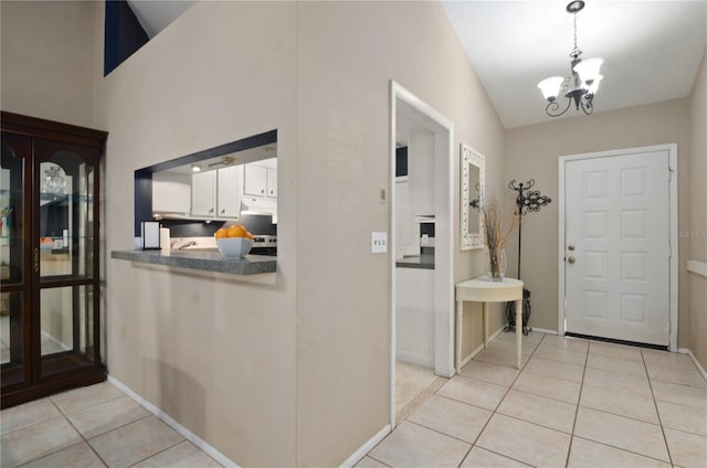 entrance foyer featuring light tile patterned floors, a notable chandelier, and baseboards