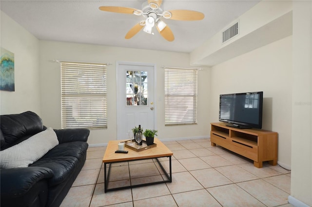 living room featuring a ceiling fan, light tile patterned floors, baseboards, and visible vents