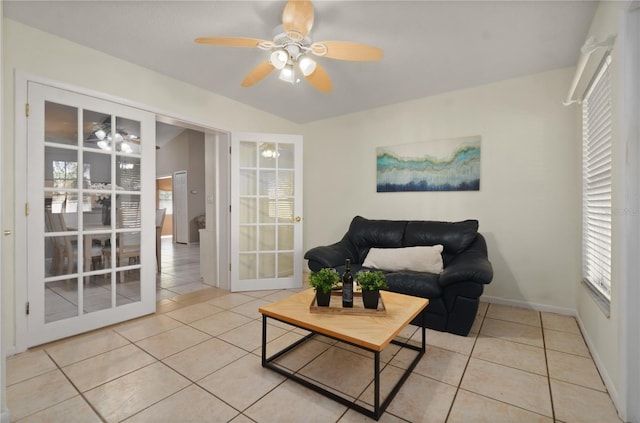 living room with light tile patterned floors, baseboards, and ceiling fan