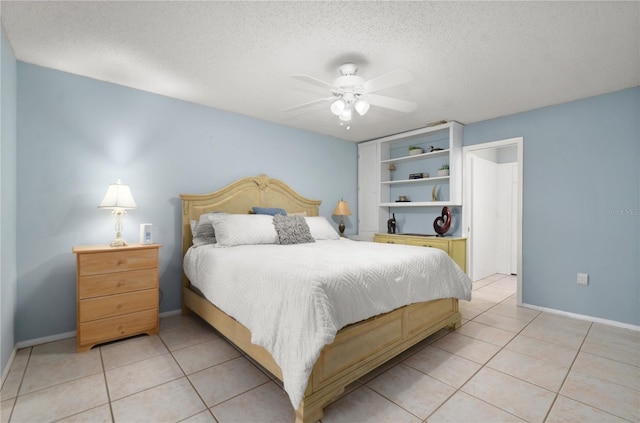 bedroom featuring light tile patterned floors, baseboards, a textured ceiling, and a ceiling fan