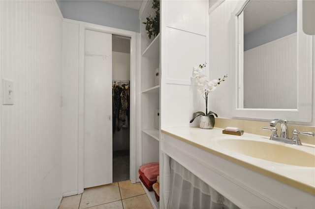 bathroom with a textured ceiling, vanity, and tile patterned flooring