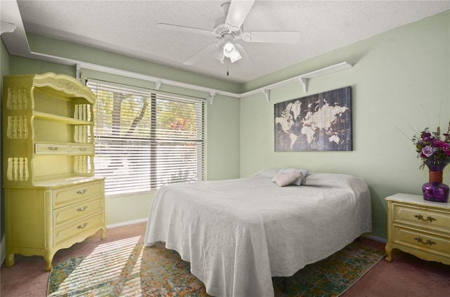 bedroom featuring baseboards, carpet flooring, a textured ceiling, and a ceiling fan