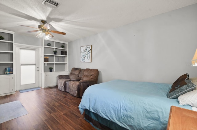 bedroom with ceiling fan, visible vents, a textured ceiling, and wood finished floors