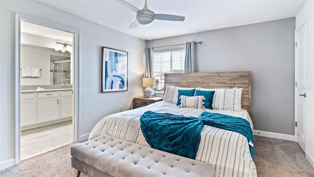 bedroom with ceiling fan, baseboards, light carpet, and connected bathroom