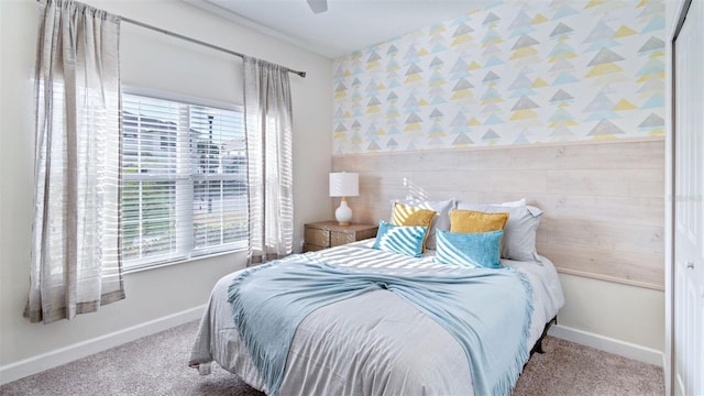 bedroom with an accent wall, multiple windows, and carpet