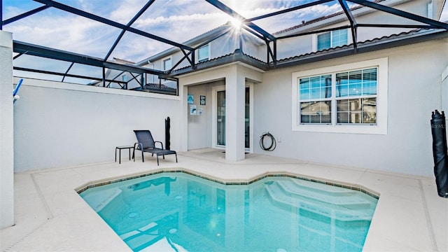 pool featuring a patio area and glass enclosure