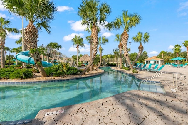 community pool featuring a water slide and a patio