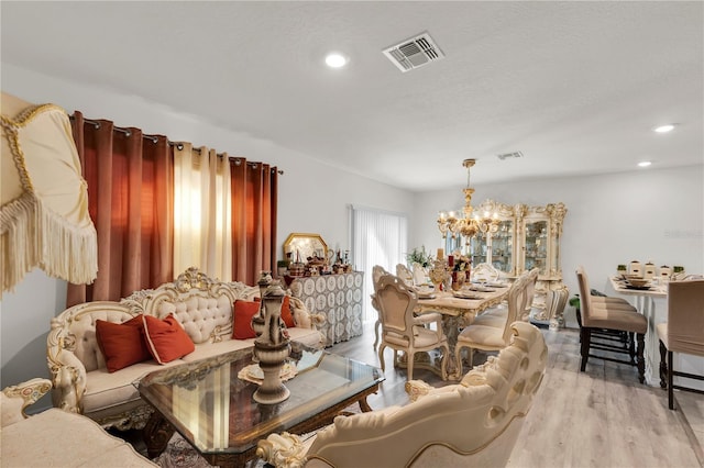 interior space with a notable chandelier, recessed lighting, visible vents, and light wood-type flooring