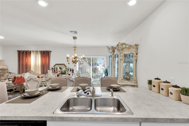 kitchen with visible vents, a chandelier, dishwasher, light countertops, and a sink