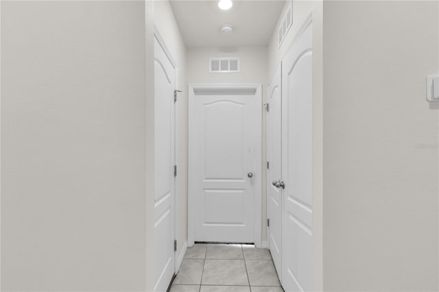 corridor featuring visible vents and light tile patterned flooring