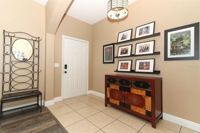 tiled foyer entrance with baseboards and arched walkways