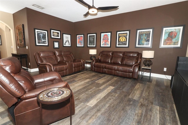 cinema featuring arched walkways, baseboards, ceiling fan, and wood finished floors