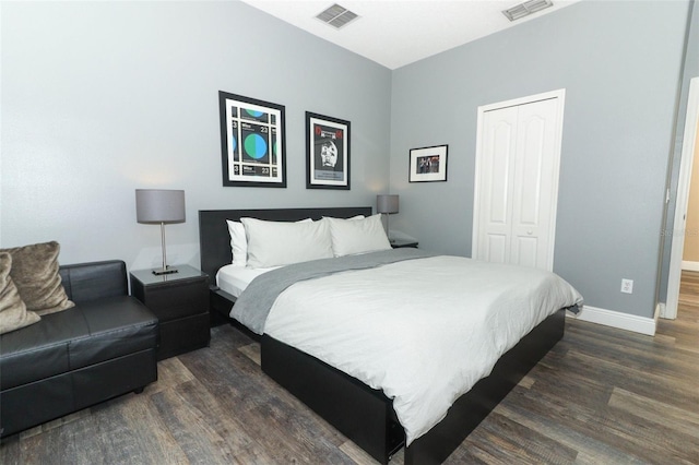 bedroom featuring dark wood-type flooring, baseboards, visible vents, and a closet