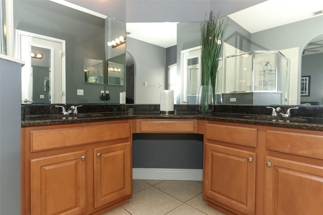 full bathroom featuring tile patterned floors, double vanity, a shower stall, and a sink