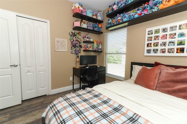 bedroom featuring dark wood finished floors, baseboards, and a closet