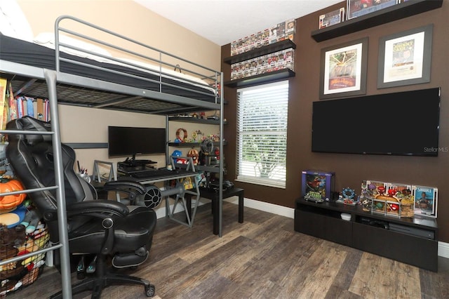 bedroom with baseboards and wood finished floors