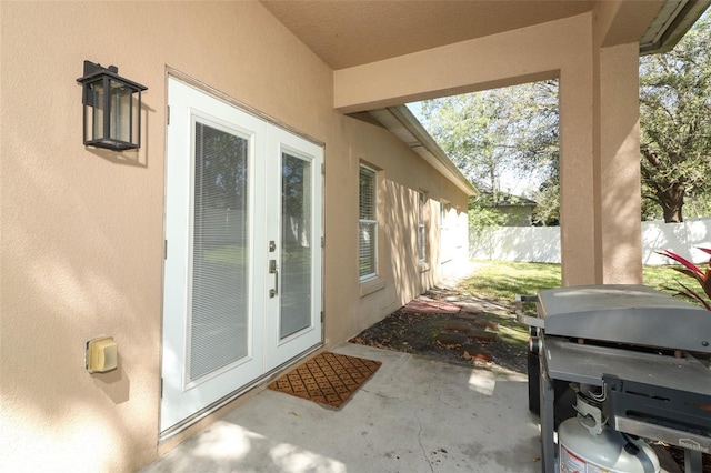 property entrance featuring stucco siding, a patio area, and fence