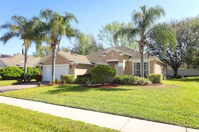 ranch-style house featuring a front lawn, an attached garage, driveway, and stucco siding